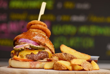 Gourmet craft bacon cheeseburger with chips and onion rings