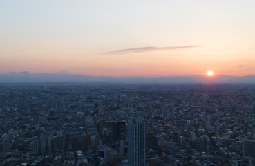 Naklejka na ściany i meble 東京都市風景　新宿高層ビル街から望む富士山　夕日が沈む　眼下に広がる街並
