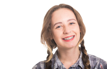 Young girl in a plaid shirt showing her dental braces