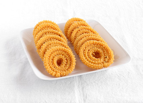 Chakli, also known as murukku, which is a south Indian traditional, popular and vegetarian snack, on a plate.