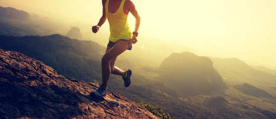 Young fitness woman trail runner running at mountain top - obrazy, fototapety, plakaty