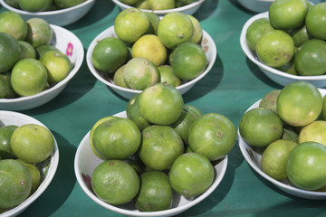 Green lemon on plate in the market.