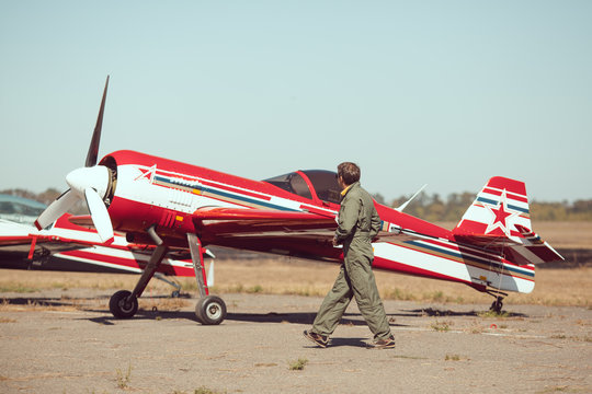 Pilot in front of vintage plane
