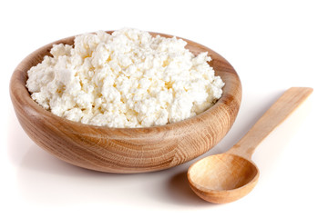 Fototapeta na wymiar Cottage cheese in a wooden bowl isolated on a white background