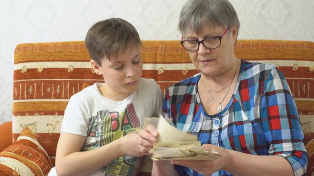 Grandmother shows her grandson the family photos