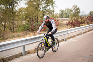 Man cycling in autumn park