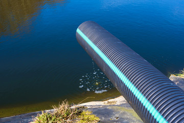 Landfill leachate pouring into pond from a black and blue pipe. Location Ronneby, Sweden. - 143892890
