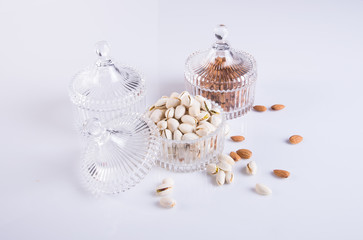 almonds and pistachio in glass bowl on a background.