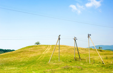 Fototapeta na wymiar Three high voltage wires on a hill