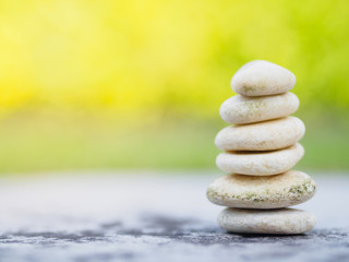 Balance Stones stacked to pyramid in the soft green background to Spa ideas design or freedom and stability concept on rocks.