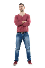 Happy young smiling casual man wearing jeans with crossed arms looking up.  Full body length portrait isolated over white background. 