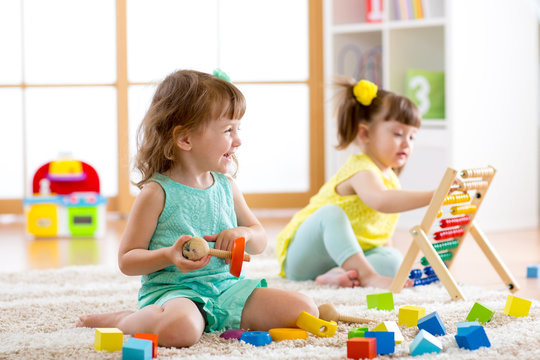 Little kids playing with abacus and constructor toys in kindergarten, playschool or daycare center