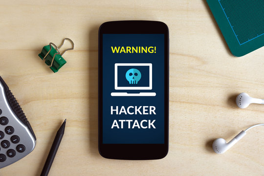 Hacker attack concept on smart phone screen on wooden desk. All screen content is designed by me. Flat lay