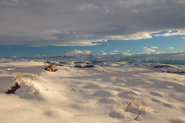 Russia. The formation and movement of clouds above the volcano Elbrus in the Caucasus Mountains in winter.