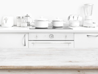 Fototapeta na wymiar Wooden table in front of blurred white kitchen bench interior