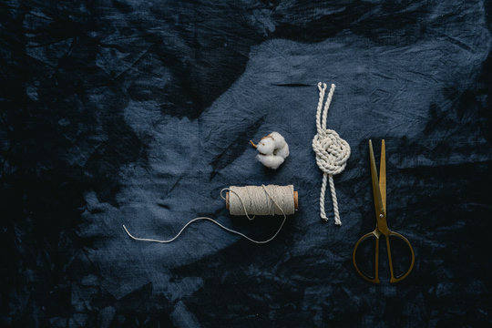 Tabletop with indigo cloth, yarn and scissors