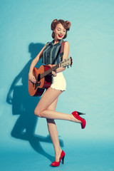 Obraz premium the girl in red shoes with guitar on blue background