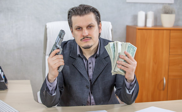 A businessman is showing money and a gun in both hands.