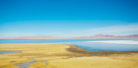 Beautiful lake and yellow fields scenery in Tibet .