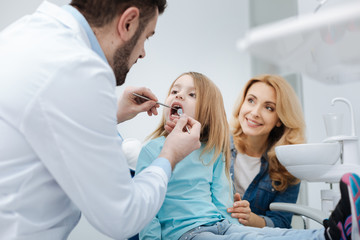 Attentive mom brining her child to the dentist - obrazy, fototapety, plakaty