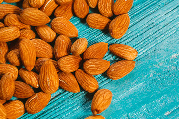 handful of almonds on a blue wooden background