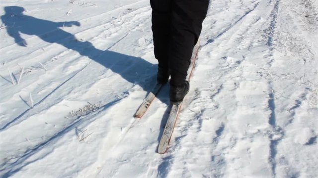 feet go skiing/feet of man go skiing on snow in winter