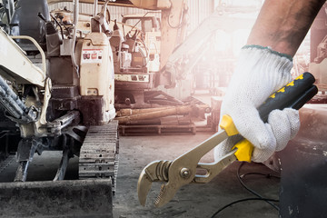 Close up of a human hand holding a tool for maintenance or machine service in the workshop.