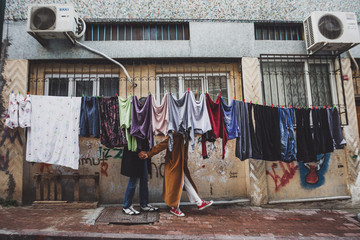 Fototapeta na wymiar Young couple having fun in drying laundry hanging at old streets of Istanbul