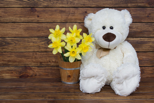 white teddy bear with bouquets