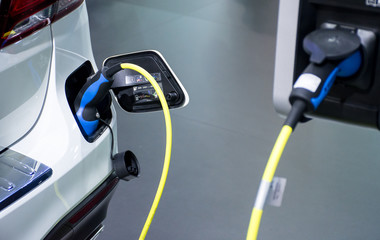 Electric car charging, EV while charging. Close up of power supply plugged
