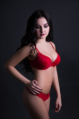 Fototapeta premium sexy young woman in red lace lingerie over black background