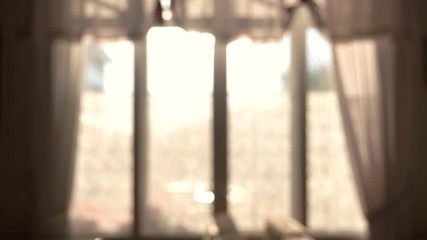 Blurred windows and curtains. Sunny day behind the window. Village house for sale.