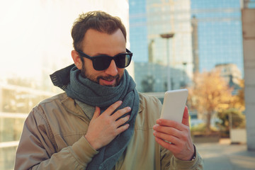 Fototapeta premium Modern guy using smartphone in the European city.