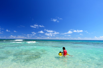 南国沖縄のビーチで遊ぶ親子
