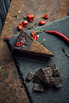 Piece of dark chocolate cake with red hot pepper. The restaurant or cafe atmosphere. Retro. Vintage