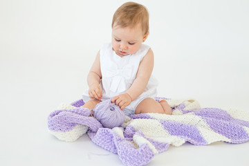 Fototapeta premium Little baby girl playing with threads ball.