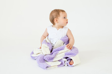 Pretty little baby girl sitting on floor with plaid isolated