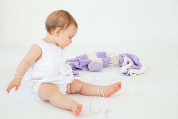 Little baby sitting on floor with plaid. Focus on plaid.