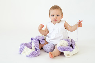 Cute little baby girl sitting on floor with plaid