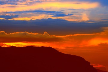 sunset in sky and cloud, beautiful colorful twilight time with mountain silhouette