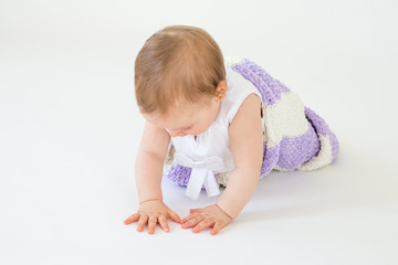 Cute little baby girl sitting on floor with plaid