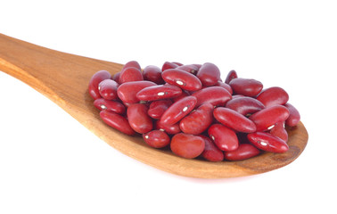 Red beans in a wooden spoon on a white background