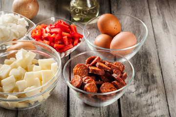 Tortilla de patatas. Ingredients for preparing spanish omelette with sausage chorizo, potatoes, paprika and egg