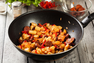 Tortilla de patatas. Cooking spanish omelette with sausage chorizo, potatoes, paprika in the pan