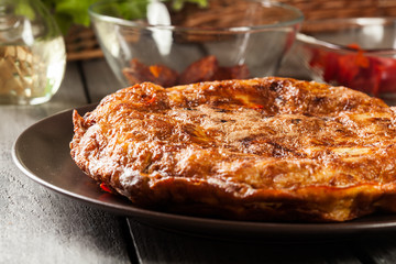 Tortilla de patatas. Spanish omelette with sausage chorizo, potatoes, paprika and egg, accompanied by olive oil