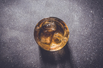 Glass of whiskey on gray stone background. Close up