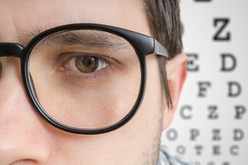 Man with glasses is testing his sight. Closeup view on eye.