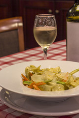 Italian pasta and glass of wine on the table in restaurant.close