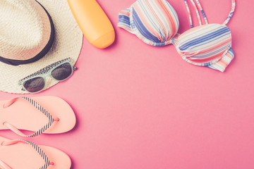 Summer background with straw hat, flip flops, swimsuit and sunglasses. Top view