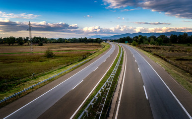 Empty open highway through pastoral landscape